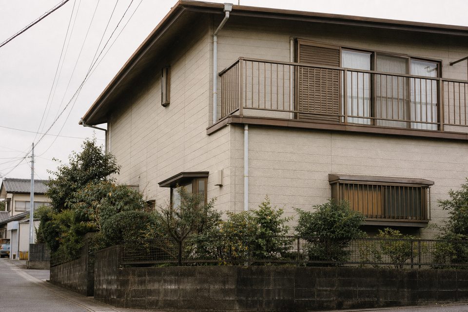 築年数の経った戸建ての外壁とベランダ